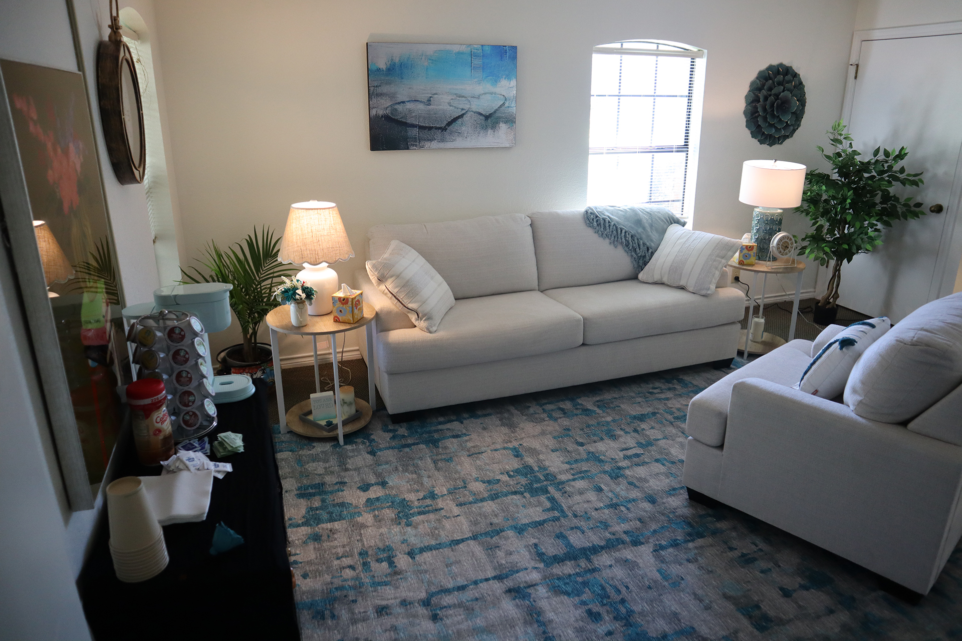 Pictured is the seating that Melissa Hunter uses in her practice of counseling patients and couples. pIctured is a full size couch in the background, a single chair in the foreground and and coffee station.